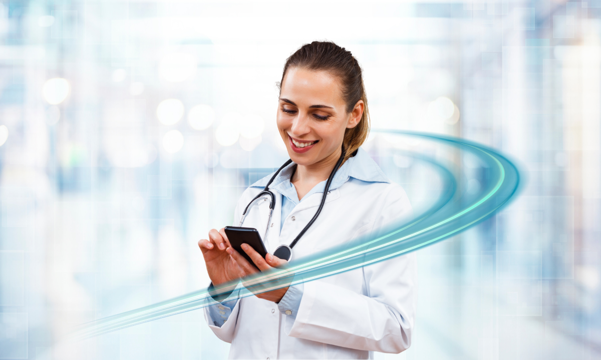 A woman standing and using her phone to access a Unified Communication platform.